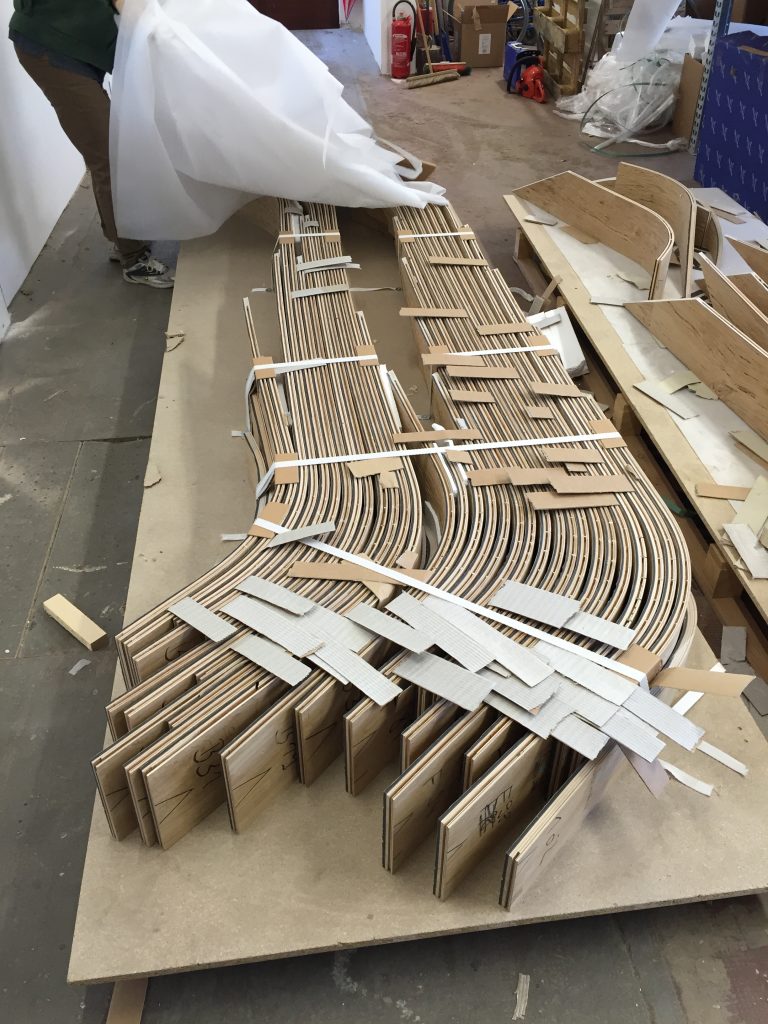 Zusammengebundene Rohteile für die Holzackierung, sie liegen auf einer Holzplatte.